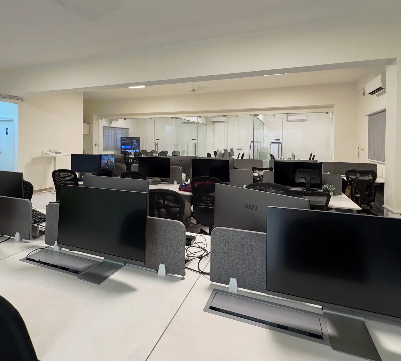 Open-plan office floor with ergonomic desks and dual monitors at KV Consulting Bangalore